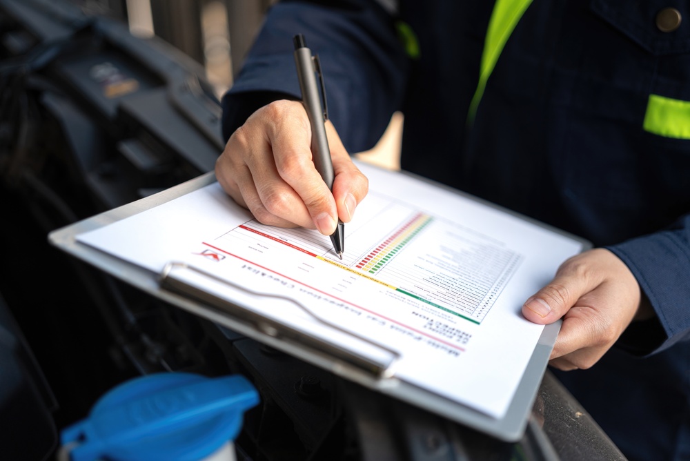 a,technician,is,checking,on,car,inspection,checklist,form,to